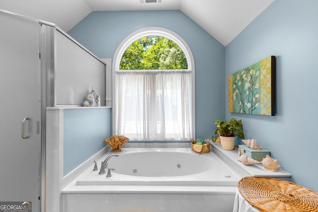 bathroom featuring a bath and lofted ceiling