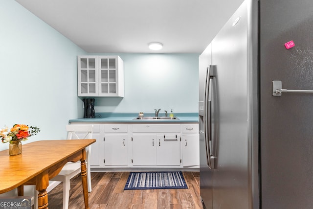 kitchen featuring white cabinets, dark hardwood / wood-style floors, sink, and stainless steel refrigerator