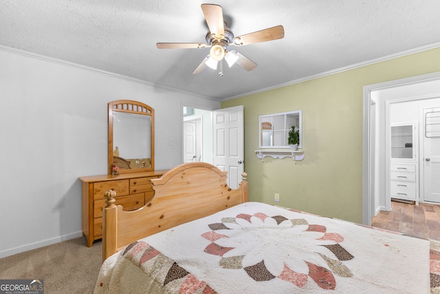 carpeted bedroom featuring ceiling fan, ornamental molding, a textured ceiling, and a closet