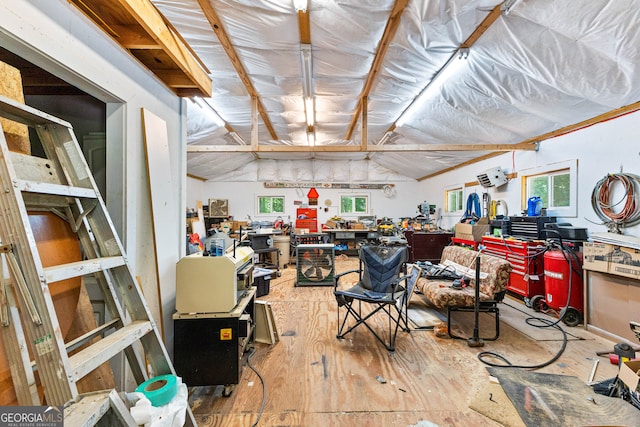 misc room featuring a workshop area, a wall mounted air conditioner, a healthy amount of sunlight, and vaulted ceiling