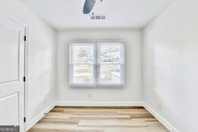 empty room with ceiling fan and light hardwood / wood-style flooring