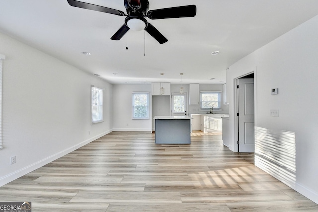 unfurnished living room featuring sink and light hardwood / wood-style flooring