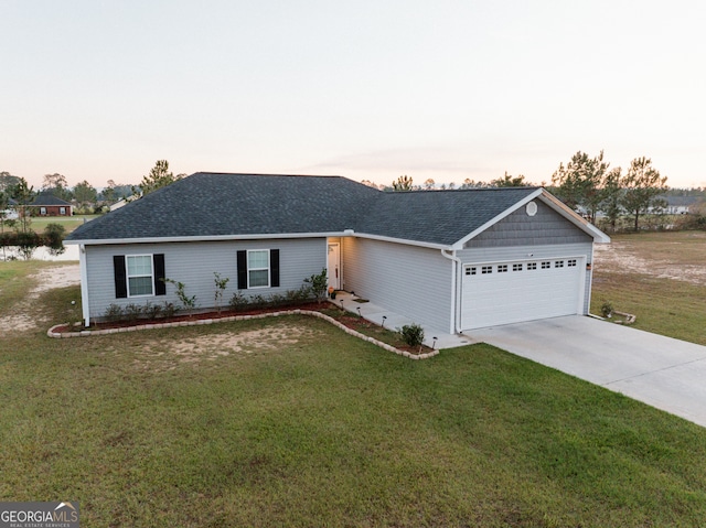 ranch-style house featuring a yard and a garage