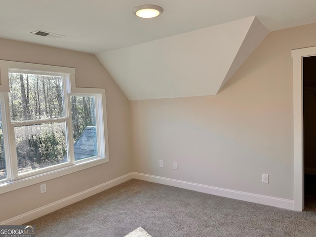 bonus room with carpet flooring and vaulted ceiling