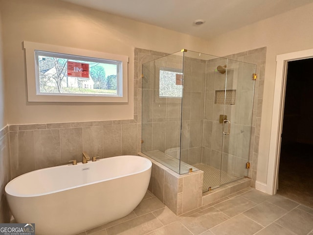 bathroom featuring tile patterned flooring and shower with separate bathtub