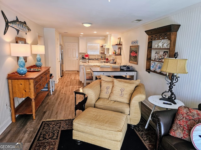 living room with hardwood / wood-style flooring, ornamental molding, and sink