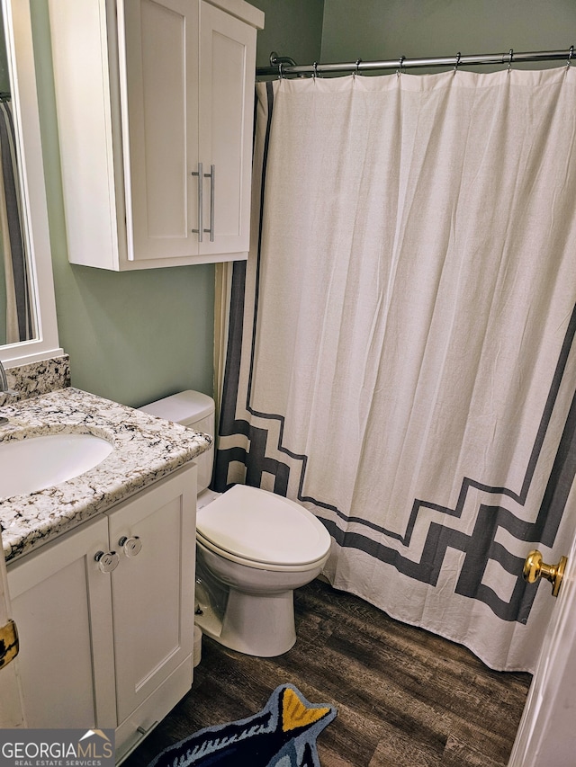 bathroom featuring wood-type flooring, vanity, and toilet