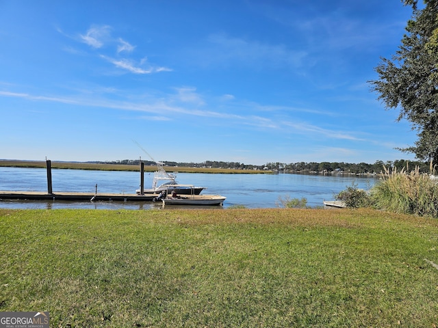 view of dock with a water view and a lawn