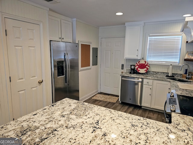 kitchen with white cabinets, sink, dark hardwood / wood-style floors, appliances with stainless steel finishes, and light stone counters