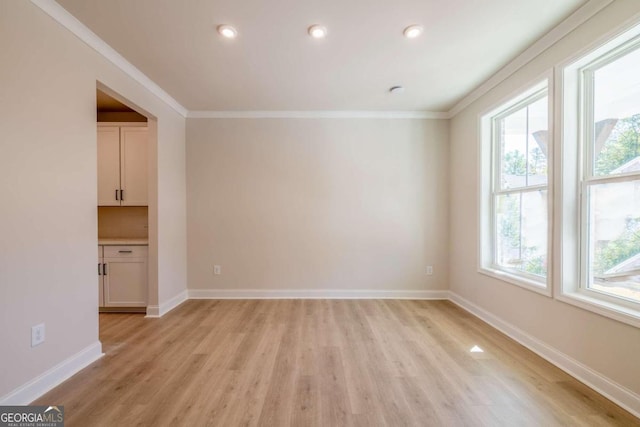 empty room featuring light hardwood / wood-style flooring and ornamental molding