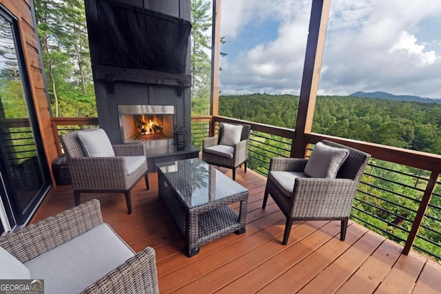 wooden deck featuring exterior fireplace