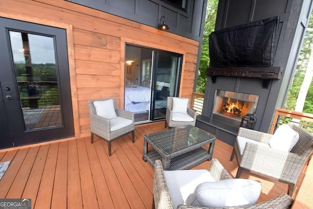 deck featuring exterior fireplace