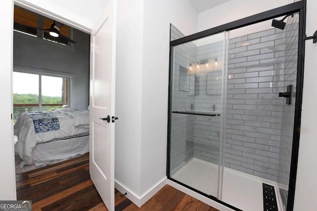 bathroom with hardwood / wood-style flooring and a shower with shower door