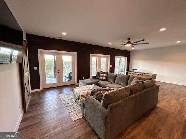 living room with dark wood-type flooring, ceiling fan, and french doors