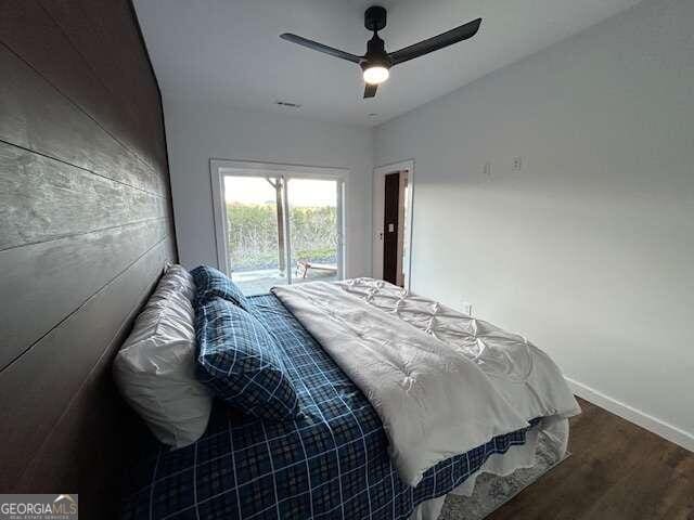 bedroom with dark wood-type flooring, ceiling fan, and access to outside