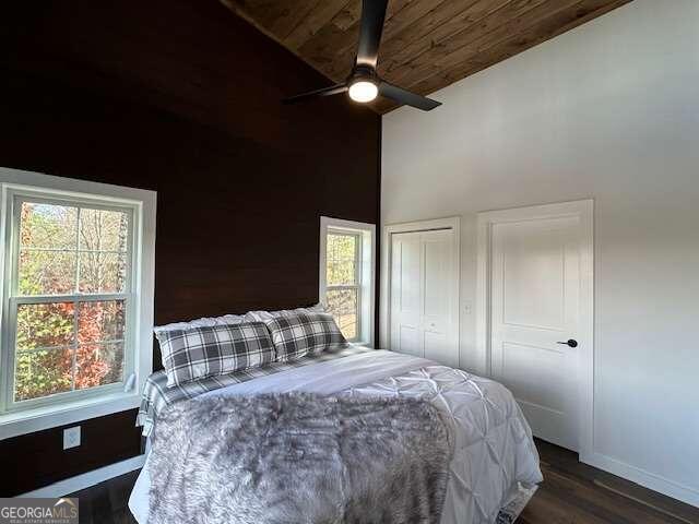 bedroom with multiple windows, vaulted ceiling, dark wood-type flooring, and ceiling fan