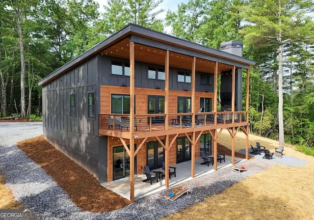 rear view of property with a fire pit and a patio area