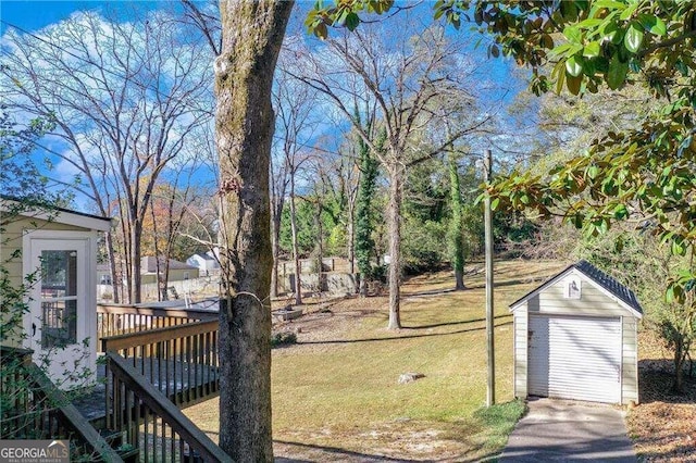 view of yard with a garage, an outdoor structure, and a wooden deck