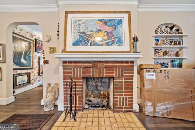 interior details with built in shelves, crown molding, a fireplace, and hardwood / wood-style floors