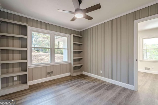 spare room with ceiling fan, ornamental molding, and light wood-type flooring