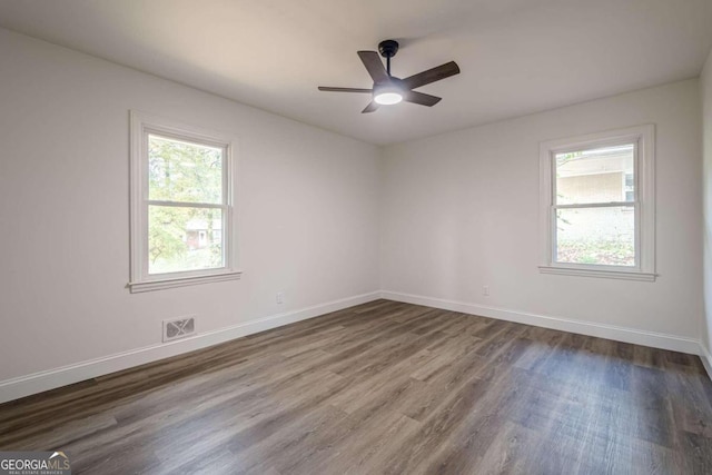 spare room featuring dark hardwood / wood-style flooring, plenty of natural light, and ceiling fan