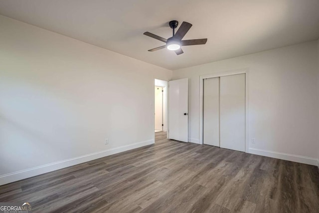 unfurnished bedroom featuring a closet, dark hardwood / wood-style floors, and ceiling fan