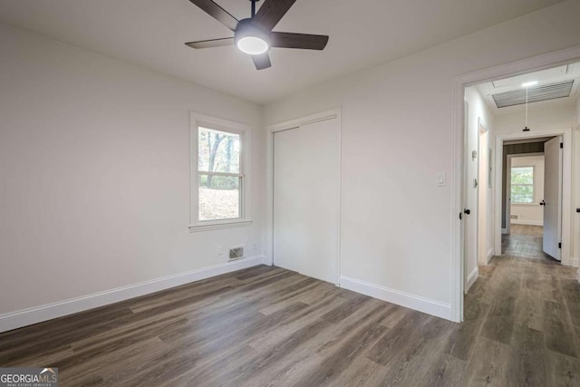 unfurnished room with ceiling fan and dark wood-type flooring