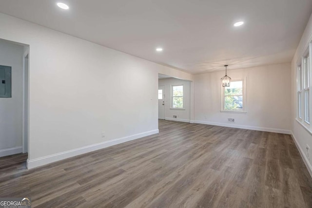 unfurnished room featuring electric panel and dark hardwood / wood-style floors