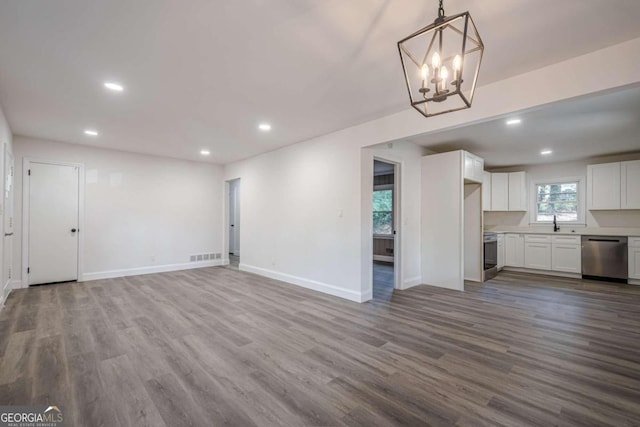 unfurnished living room with a chandelier and hardwood / wood-style floors