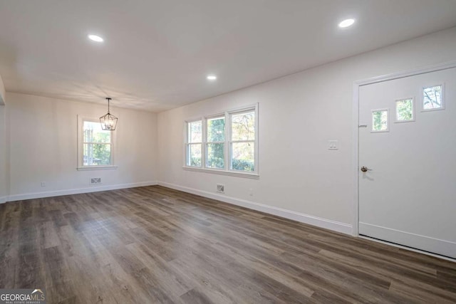 foyer entrance with a notable chandelier and dark hardwood / wood-style floors