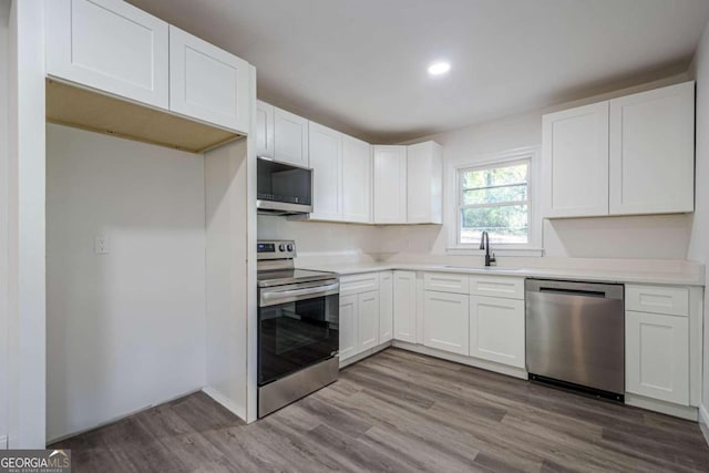 kitchen featuring white cabinets, light hardwood / wood-style floors, sink, and appliances with stainless steel finishes