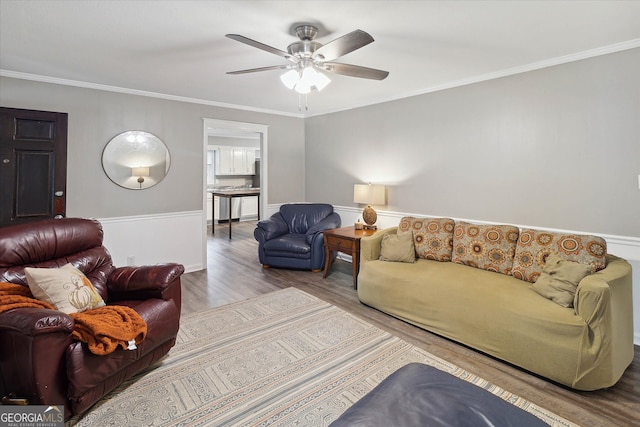 living room featuring hardwood / wood-style flooring, ceiling fan, and ornamental molding