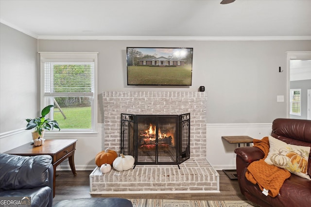 living room with dark hardwood / wood-style floors, a brick fireplace, plenty of natural light, and ornamental molding