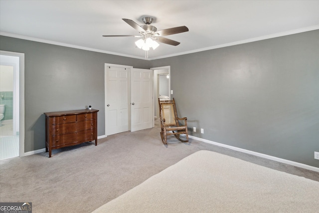 carpeted bedroom with ceiling fan, ornamental molding, and ensuite bathroom