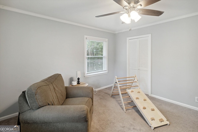 sitting room with crown molding, ceiling fan, and light colored carpet