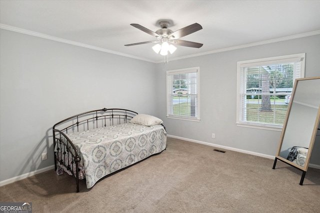 carpeted bedroom featuring ceiling fan and ornamental molding