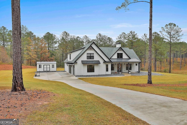 modern farmhouse with covered porch, a front lawn, and a storage unit