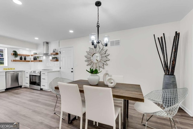 dining area featuring a chandelier and light hardwood / wood-style floors