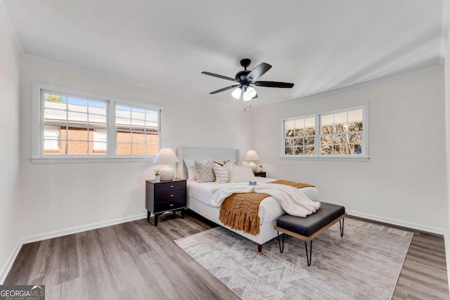 bedroom featuring wood-type flooring, ceiling fan, and ornamental molding