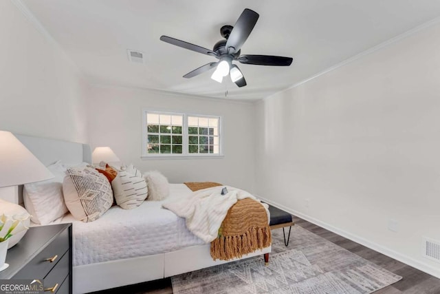 bedroom featuring ceiling fan, hardwood / wood-style floors, and crown molding