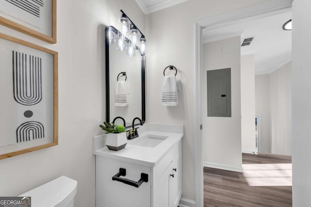 bathroom with hardwood / wood-style floors, vanity, electric panel, toilet, and ornamental molding