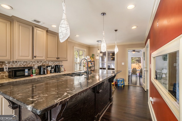 kitchen with a kitchen breakfast bar, dark wood-type flooring, sink, and a healthy amount of sunlight