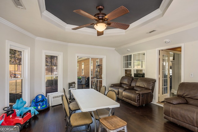 dining area featuring dark hardwood / wood-style floors, ceiling fan, ornamental molding, and a tray ceiling