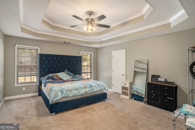 carpeted bedroom featuring a raised ceiling, multiple windows, and ceiling fan