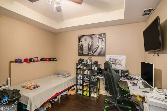 office space with dark hardwood / wood-style flooring, a raised ceiling, and ceiling fan