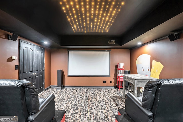 cinema room with carpet and a tray ceiling