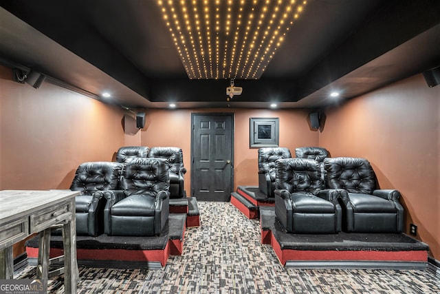 cinema room featuring carpet flooring and a raised ceiling