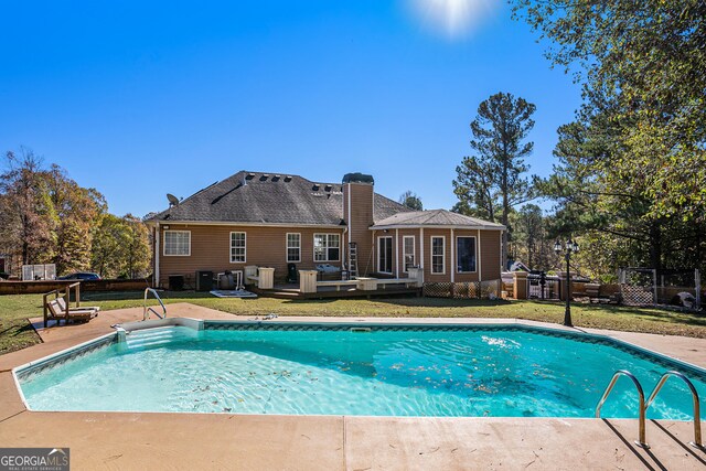 view of pool featuring a lawn and a wooden deck