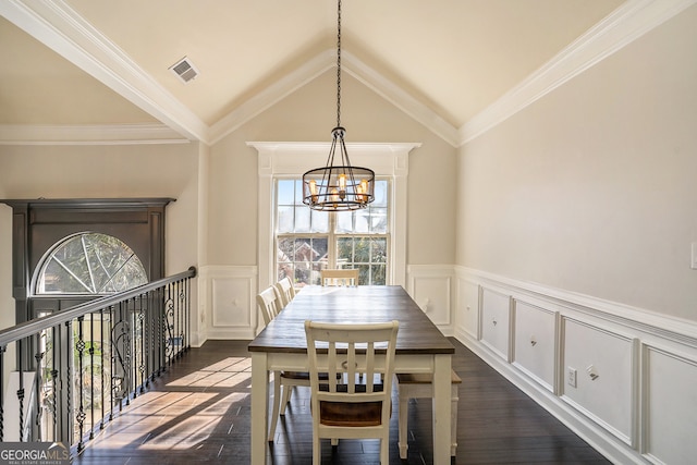 dining room featuring crown molding, dark hardwood / wood-style flooring, lofted ceiling, and an inviting chandelier