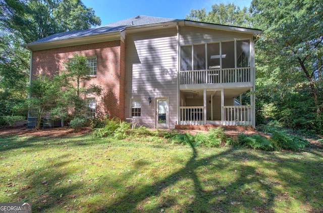 back of property with a yard and a sunroom